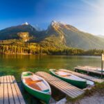bateaux amarrés au bord d'un lac en automne, montagne à l'horizon